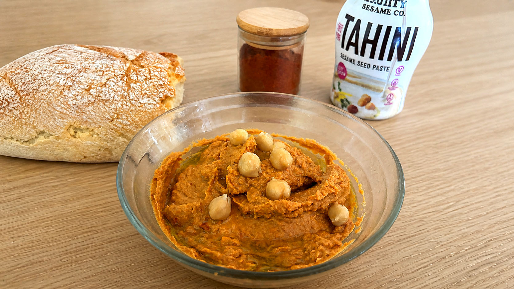Hummus di pomodori secchi e paprika in una ciotola con olio e spezie
